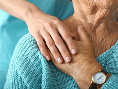 Pflegekraft unterstützt ältere Frau in der Klinik, Nahaufnahme